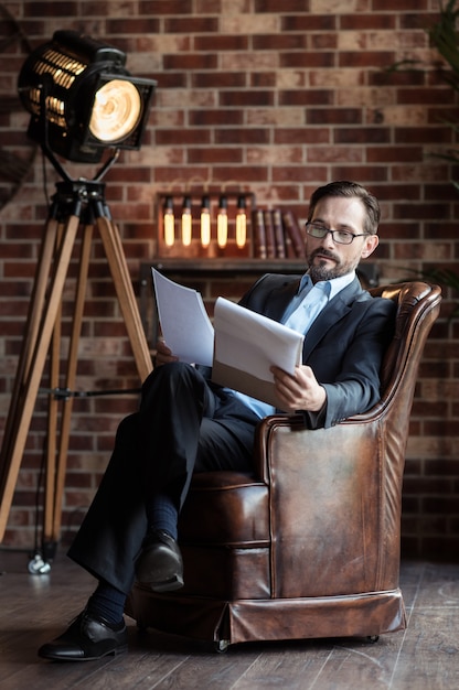 A photograph of a director sitting at a table with actors, going over scripts, and discussing character interpretations. The atmosphere is one of collaboration and focus, with scripts and notes scattered around the table.
