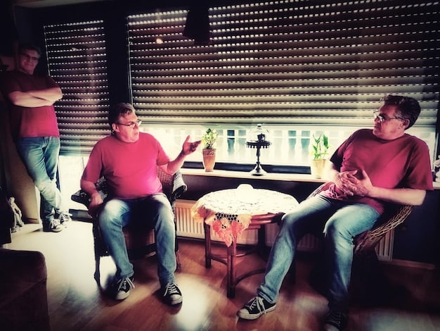 A group photo of the Squid Game Season 2 cast at a script reading session. The actors are sitting around a table, focused and engaged in the script, indicating thorough preparation and dedication. The atmosphere is professional and collaborative.