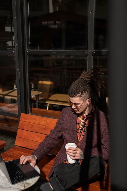 A person sitting in a coffee shop uses their laptop while also watching a streaming video on their smartphone. The smartphone is connected to the coffee shop's public Wi-Fi network, and a VPN app is running in the background to secure the connection.